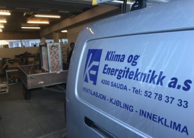 Bil som det står Klima og Energiteknitt på med en tilhenger og last