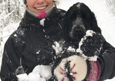 Emilie Sandal med ett stort smil og en hund i armene