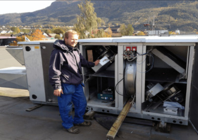 En arbeider ved Klima og Energiteknitt som undersøker en installasjon