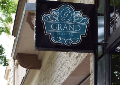 Mockup av Grand hotell sin logo på ett skilt